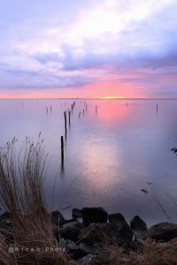 zonsopkomst boven Markermeer met fuikenstokken