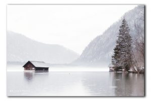 Allmsee met botenhuis in de regen en mist