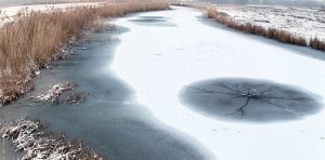 Winter in Nederland met een wak in het ijs